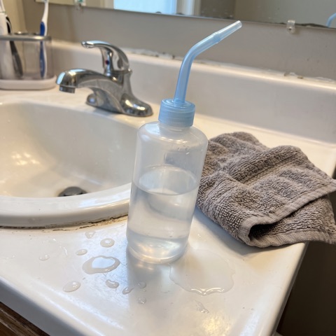 A squeeze bottle on the edge of the sink